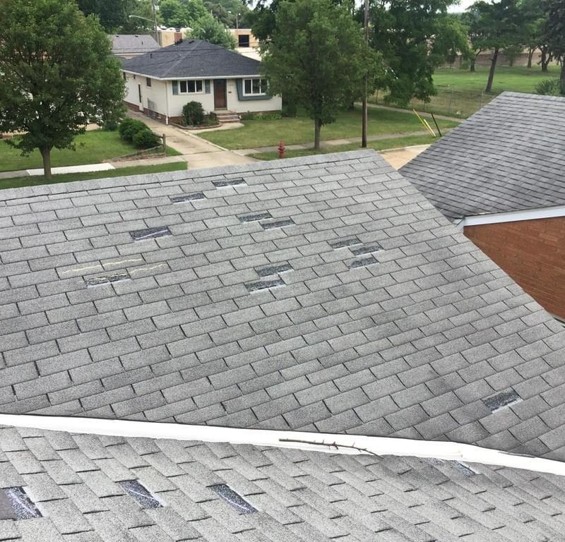 Roof with missing shingles due to wind damage